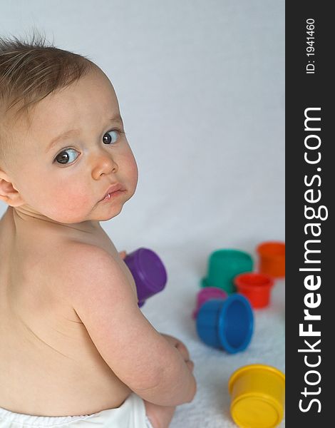 Image of adorable baby playing with stacking cups. Image of adorable baby playing with stacking cups