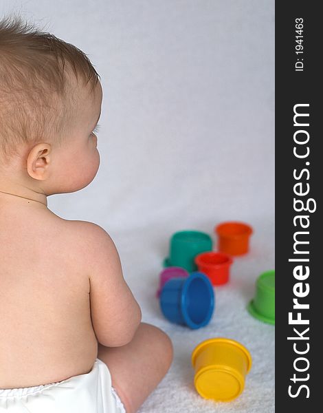 Image of adorable baby playing with stacking cups. Image of adorable baby playing with stacking cups