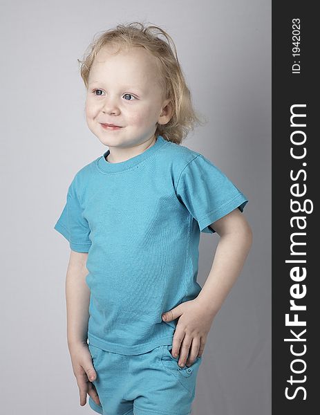 Smiling blond little child in blue clothes. Smiling blond little child in blue clothes