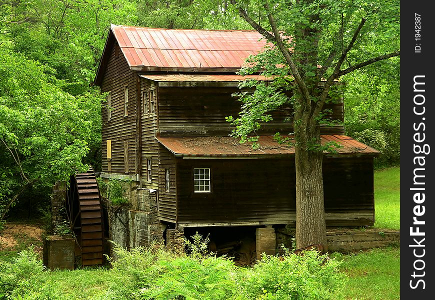 Wooden Grist mill with water wheel in forest