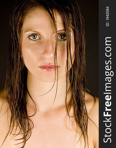 A young woman with wet hair against a plain background.