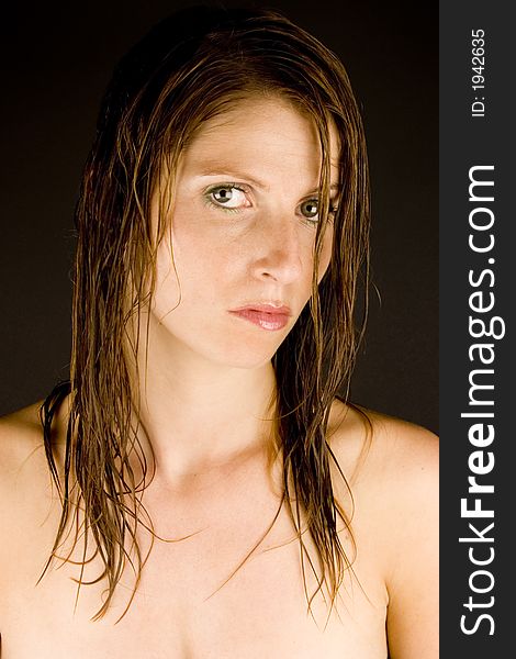A young woman with wet hair against a plain background.