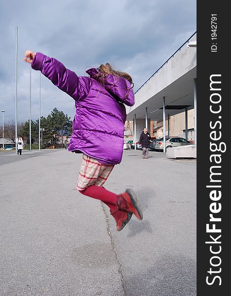 Little girl jumping happily in the city. Zagreb, Croatia.