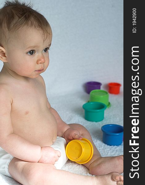 Image of adorable baby playing with stacking cups. Image of adorable baby playing with stacking cups