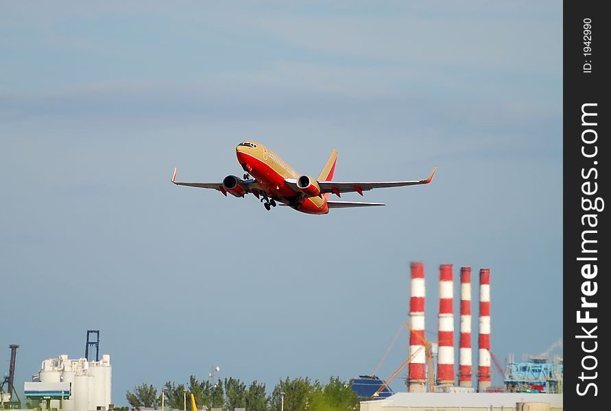 Airplane taking off against industrial smoke stacks. Airplane taking off against industrial smoke stacks