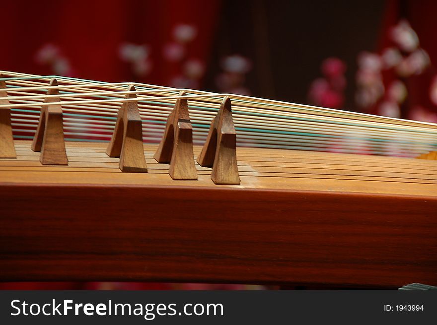 Closed up view of gu-jeng, an string musical instrument showing double string and flet. Closed up view of gu-jeng, an string musical instrument showing double string and flet