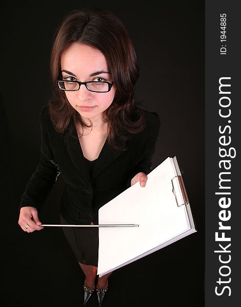 Business woman show with forefinger on a blank paper block notes, black background