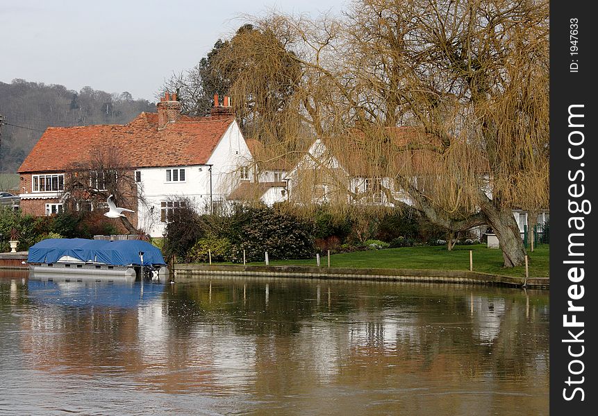 House with Boat Moorings on the banks of a River in England. House with Boat Moorings on the banks of a River in England