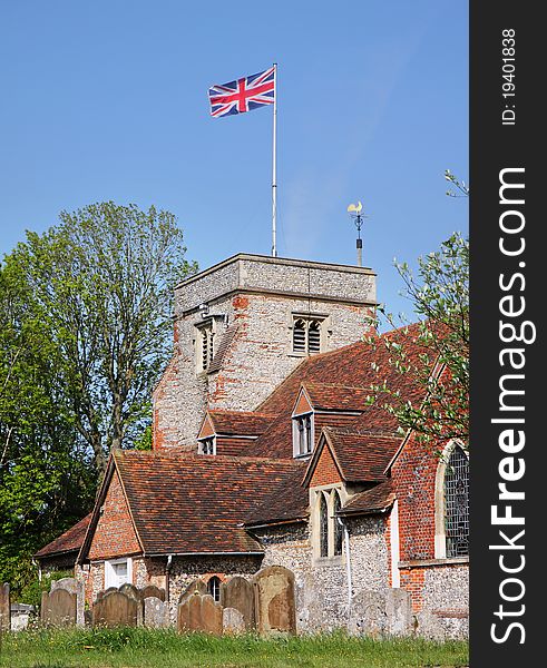 English Village Church and Tower with Union Jack Flag flying. English Village Church and Tower with Union Jack Flag flying