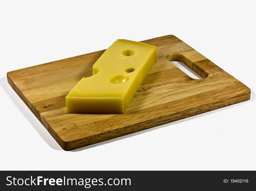 A wedge of emmental cheese on a wooden board