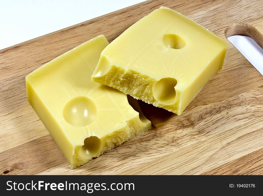 emmental cheese split in half on a wooden board
