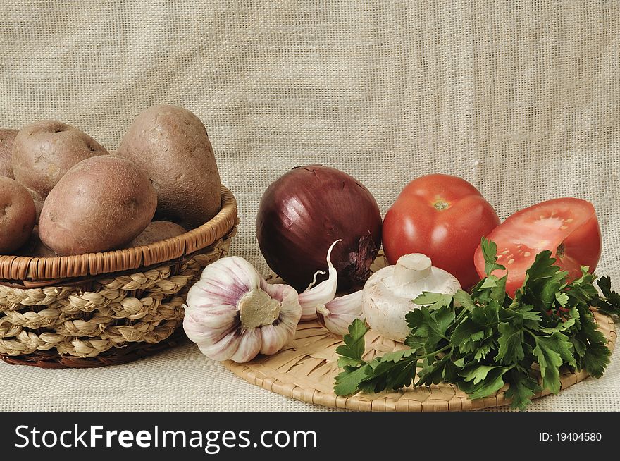 Potato, tomatoes, mushrooms, parsley, onions and garlic on wattled ware. Potato, tomatoes, mushrooms, parsley, onions and garlic on wattled ware