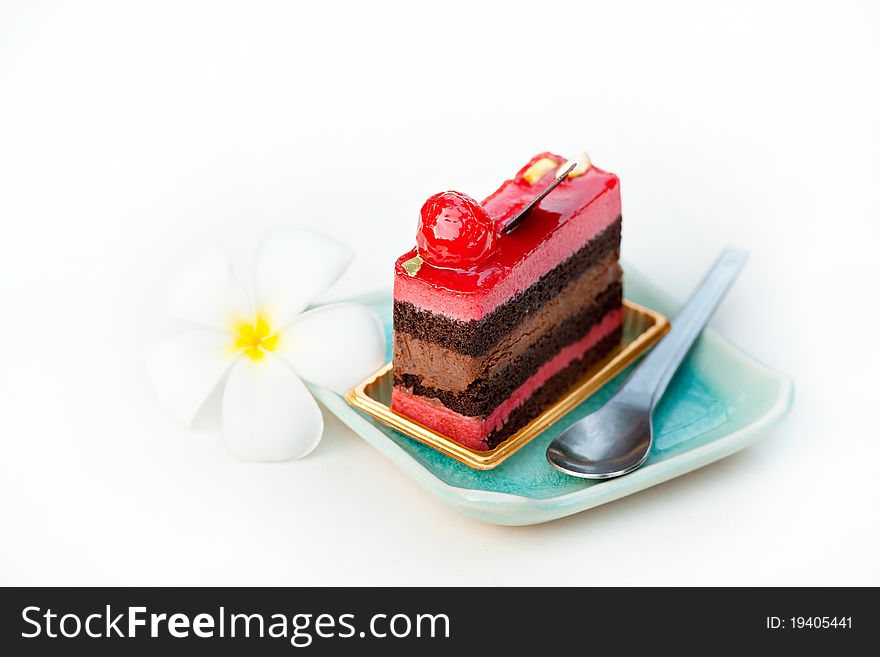 Piece of strawberry and chocolate cake and spoon