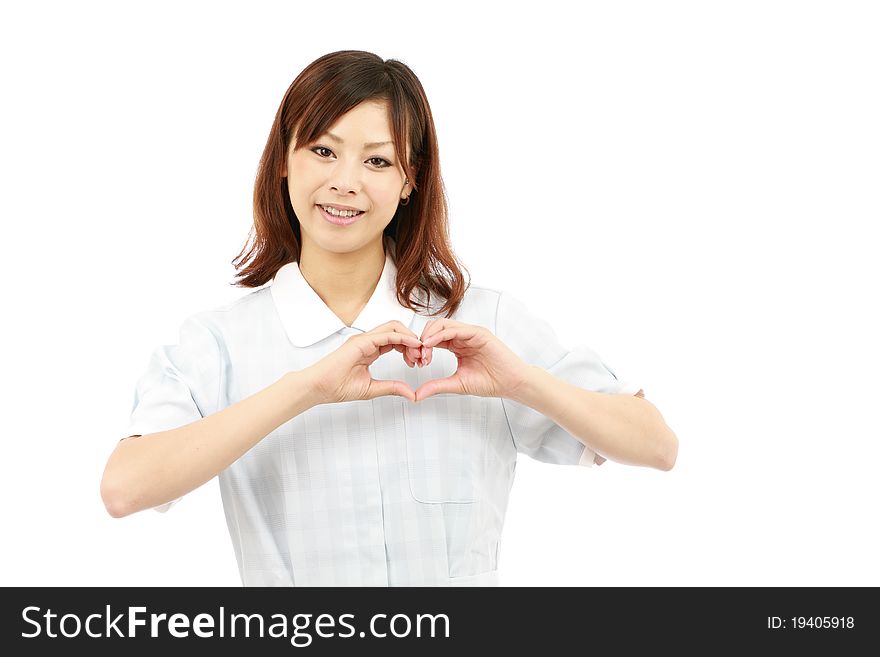 Young japanese nurse shows fingers heart symbol. Young japanese nurse shows fingers heart symbol