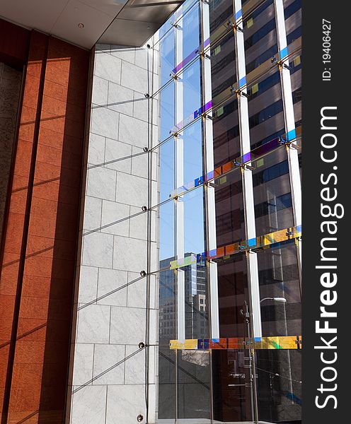 Glass and stone foyer of a modern building, other buildings seen in foreground. Glass and stone foyer of a modern building, other buildings seen in foreground