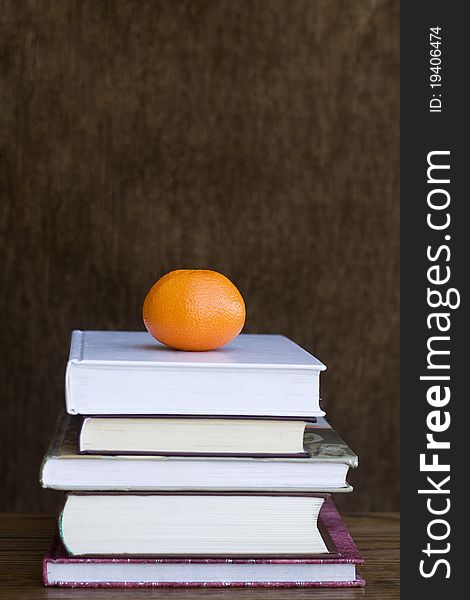 An orange on the pile of books