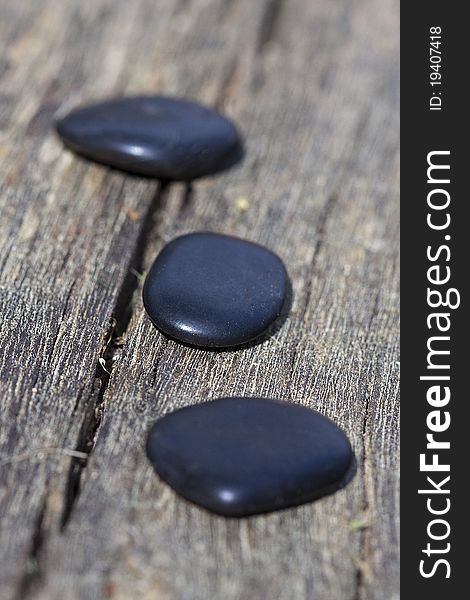 Three black stones with old wooden background. Three black stones with old wooden background