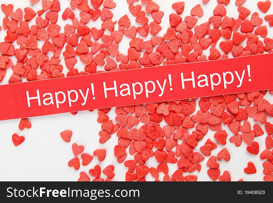 On the background of a large number of red hearts. Tasty Baking decorations. Card with text Happy. On the background of a large number of red hearts. Tasty Baking decorations. Card with text Happy