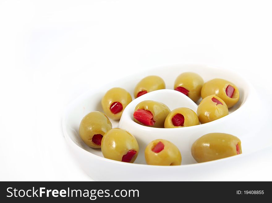Green olives with paprika on white background