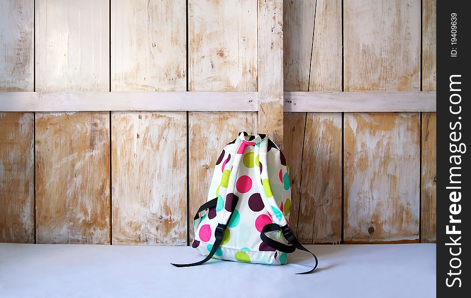 Colored backpack on wood background