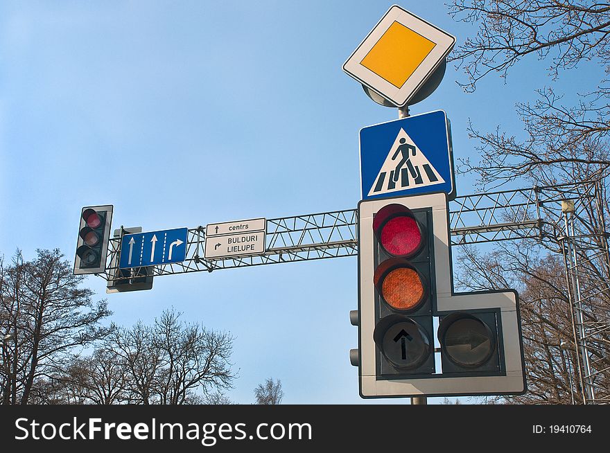 Traffic lights and road signs against sky