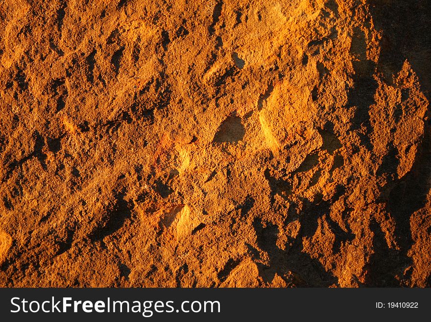 Flat rock background cast in yellow light. Flat rock background cast in yellow light