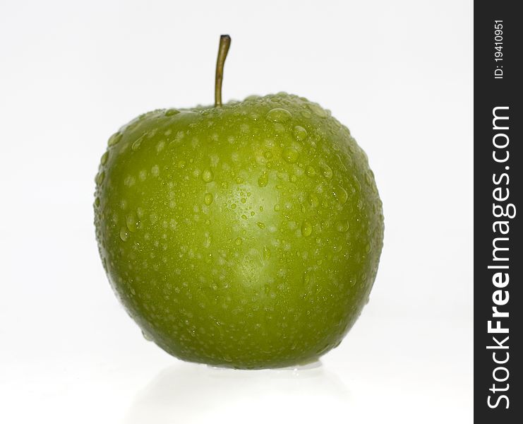 Green apple covered with water drops on a white background