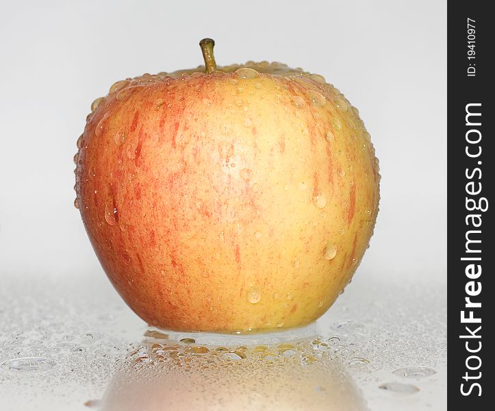 Red apple covered with water drops on a white background