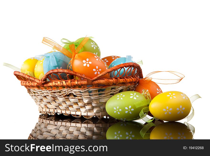 Color easter eggs in basket isolated on white