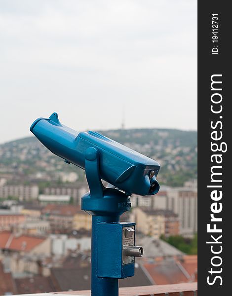 Bright blue tourist pay binoculars