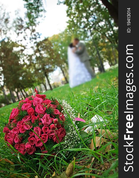 Wedding bouquet lying on a green grass on a wedding couple backgrounds.