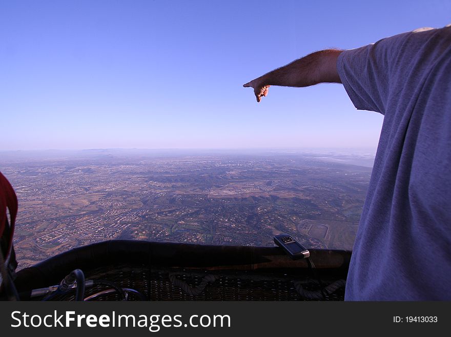 Man Points Towards the Horizon in Hot Air Balloon