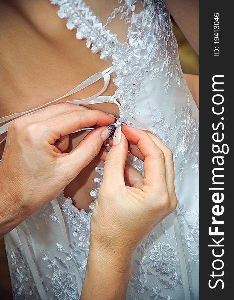 Hands Helping To Put On A Wedding Dress