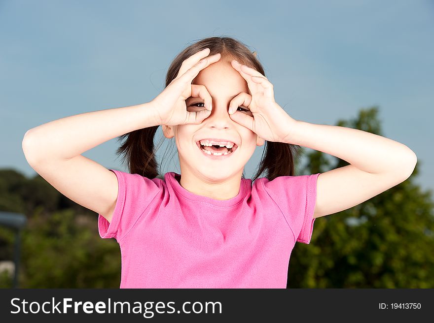 Little girl simulating binoculars with her hands