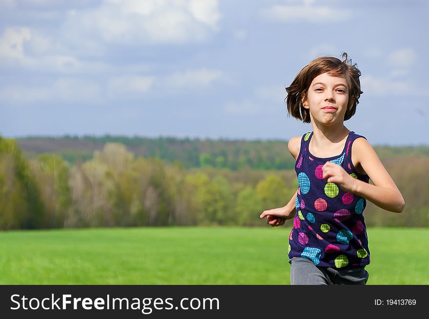 Girl running outdoors on green field. Girl running outdoors on green field