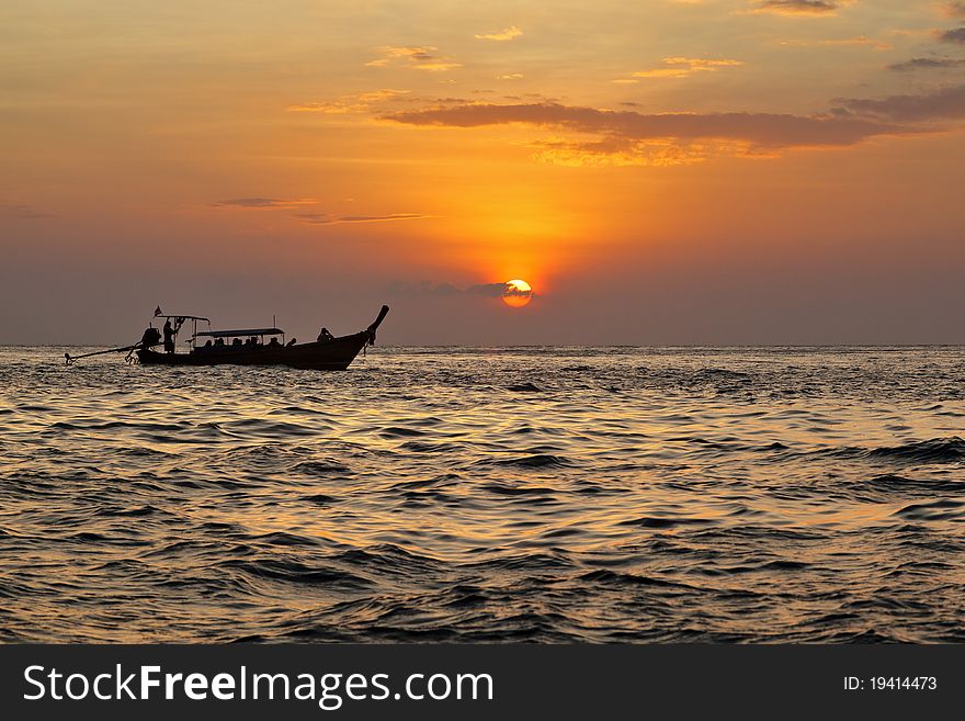 Long tail boat on andaman's sea during the sunset