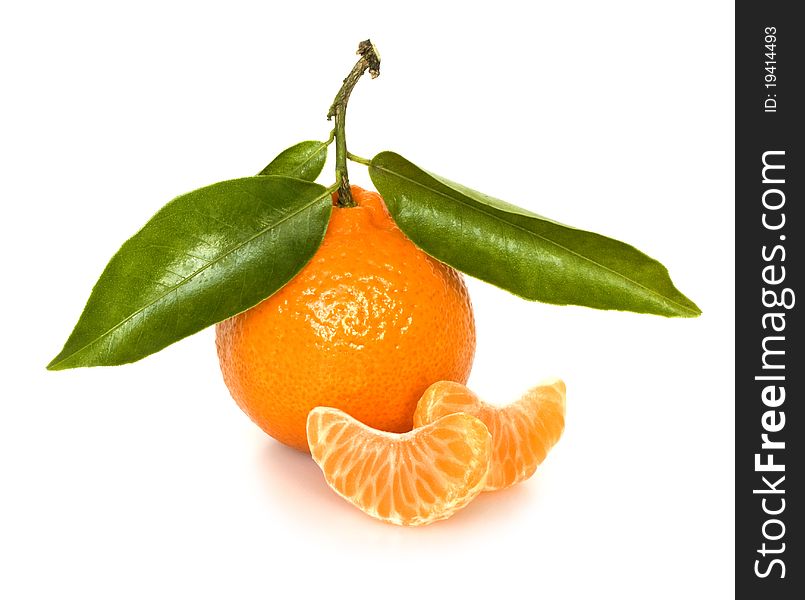 Ripe tangerine with segments and with green leaves on a white background