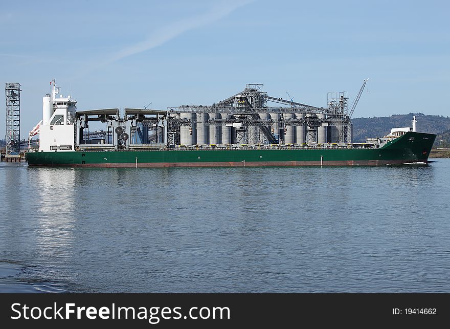 A long cargo ship moving across the agribusiness on the Columbia river, Oregon. A long cargo ship moving across the agribusiness on the Columbia river, Oregon.