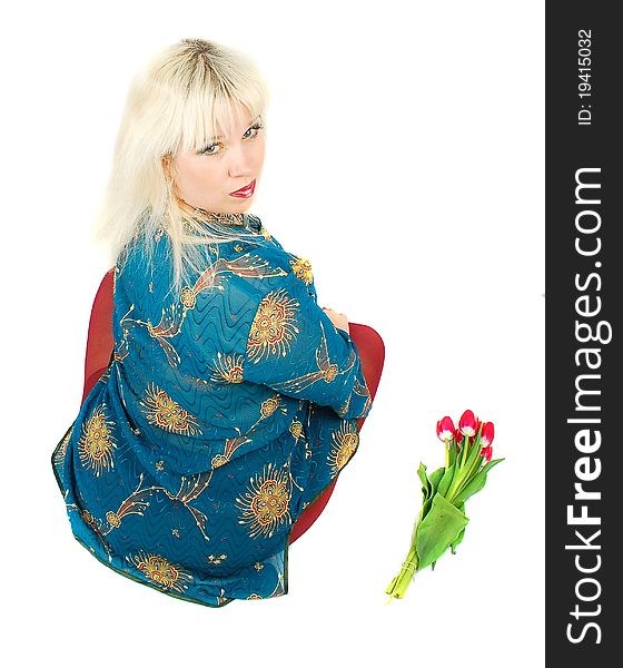 A beautiful blond woman sitting with tulips flowers on the white . Studio shoot. A beautiful blond woman sitting with tulips flowers on the white . Studio shoot.