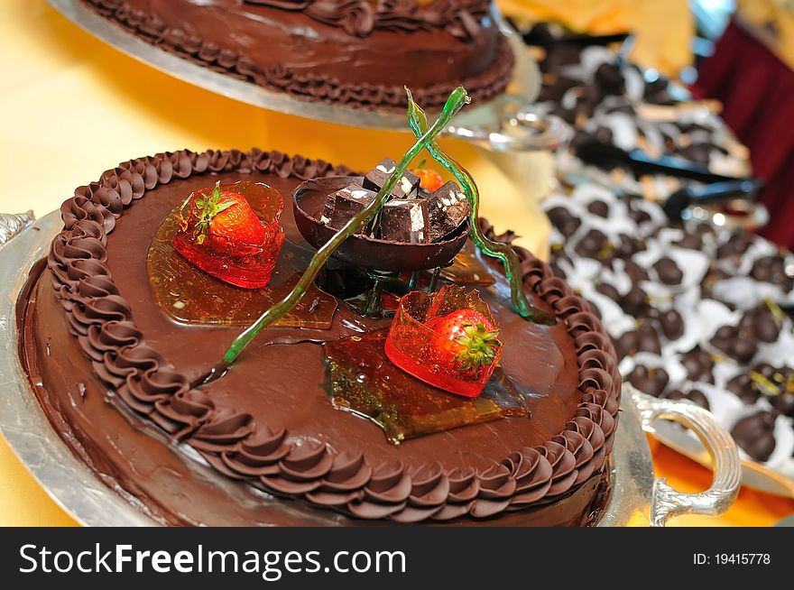 Cake coated with thick dark chocolate cream decorated with fruits. Cake coated with thick dark chocolate cream decorated with fruits.