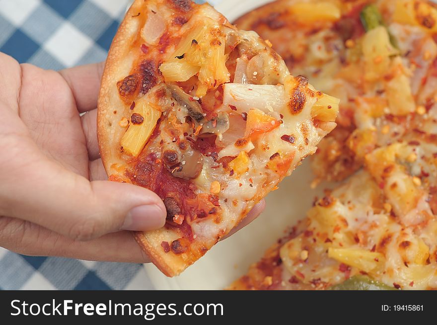 Hand taking single slice of Italian pizza. Hand taking single slice of Italian pizza.