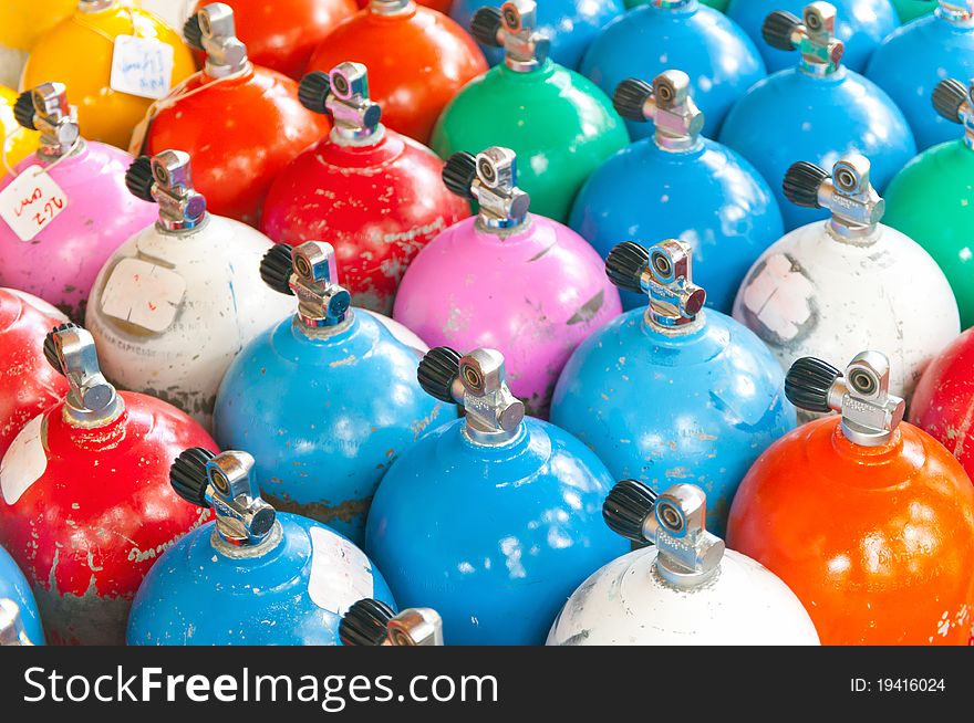 Many colorful scuba tanks in rows