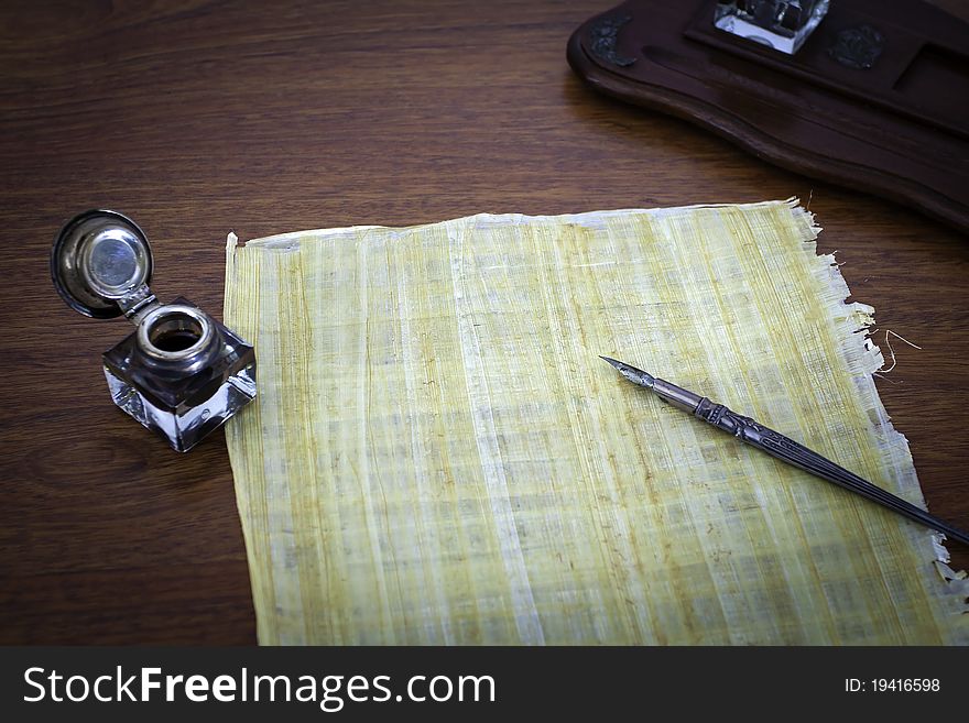 Old papyruns on a desk with ink and pen. Old papyruns on a desk with ink and pen