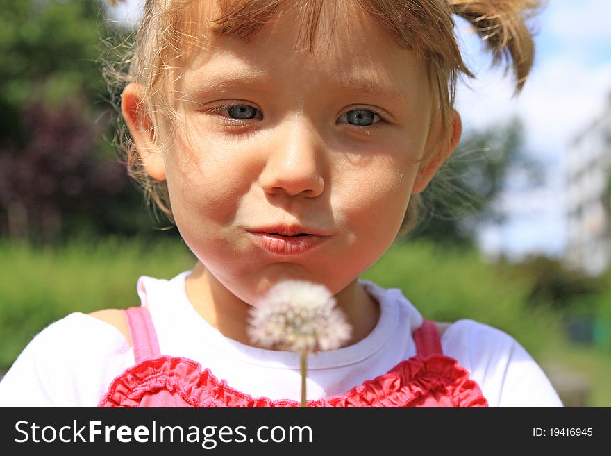 Beautiful girl blowing a dandelion