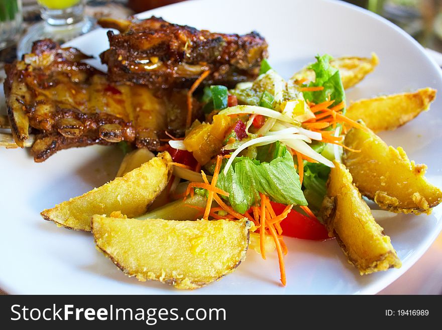 Roasted meat with fried potatoes and salad