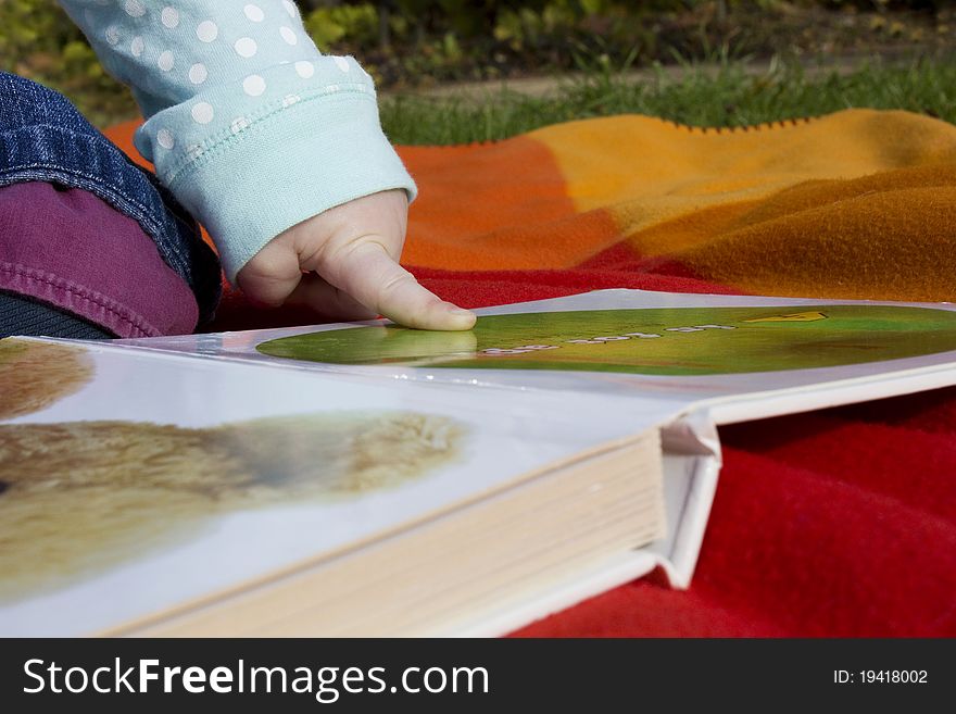 Child Reading A Book Out In The Garden