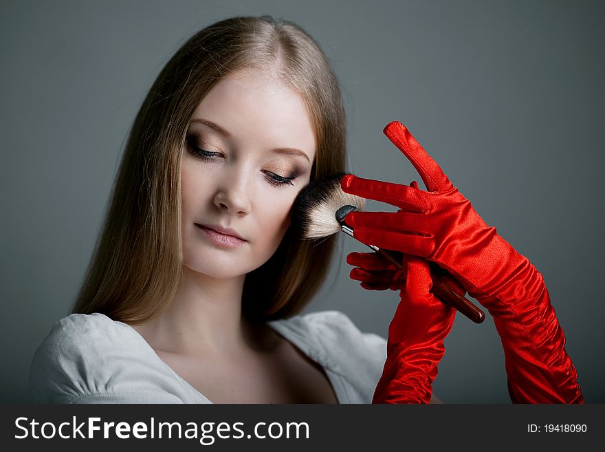 Image of girl in gloves with the professional makeup brush in her hands. Image of girl in gloves with the professional makeup brush in her hands.