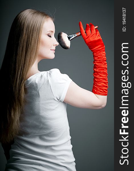 Image of girl in gloves with the professional makeup brush in her hands. Image of girl in gloves with the professional makeup brush in her hands.