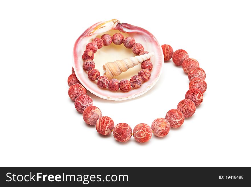 Beads and bracelet from red coral with shells isolated on white. Beads and bracelet from red coral with shells isolated on white.