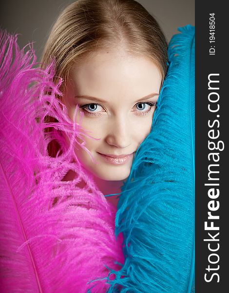 The image of a beautiful girl with colorful feathers